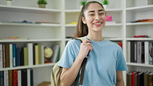 Young beautiful hispanic woman student smiling confident standing at library university
