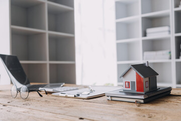 Obraz premium Real estate broker agent presenting and consult to customer to decision making sign insurance form agreement, buy and sell home model, concerning mortgage loan offer for and house insurance