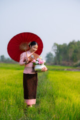 Pretty Asian women in traditional Thai dress. Beautiful traditional Thai dresses by Asian Buddhists make merit at the Temple a tourist attraction, a