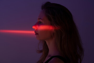Profile of a woman with red neon light on her eyes