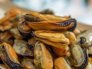 Tasty grilled mussels in a wooden paper bowl