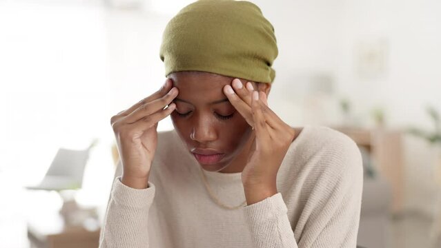 Stress, anxiety and headache by black woman of a sofa, worried and paranoid in her home. Fear, depression and girl with mental health problem in a living room, lonely and sad, afraid or addiction