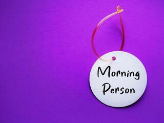 Luggage tag on red background with handwritten text MORNING PERSON, to improve overall wellness,...