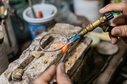Close Up Of Anonymous Jeweler Soldering A Bracelet