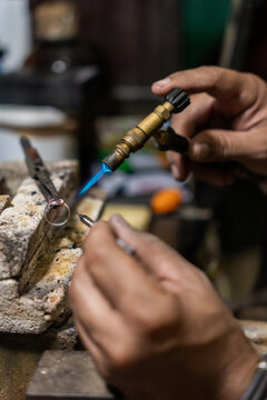 Close Up Of Anonymous Jeweler Soldering A Ring