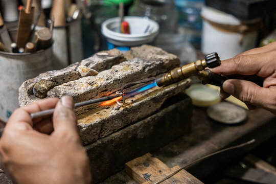 Close Up Of Anonymous Jeweler Soldering A Ring