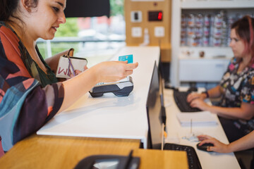 Crop woman paying by card in vet clinic