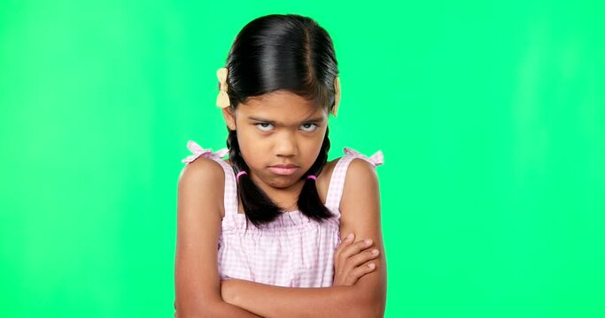 Angry, crossed arms and face of child on green screen with upset, disappointed and anger expression. Emoji, mockup studio and portrait of isolated young girl mad, unhappy and shake head for problem