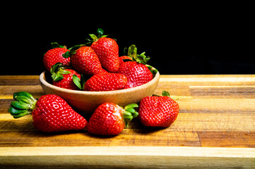 Bowl of strawberries on a wooden table