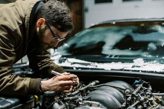 Millennial Mechanic working in engine bay of a car