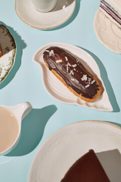 chocolate eclair surrounded by desserts and drinks