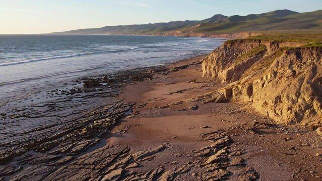 2023 - Excellent aerial footage of waves hitting the shoreline of Jalama Beach, California as the sun starts to set.