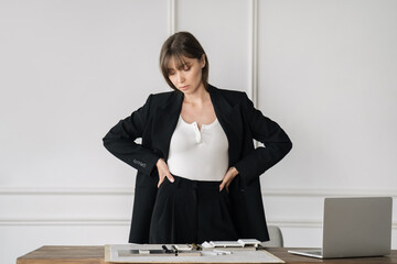 Woman in bright room with laptop and tile examples on a desk