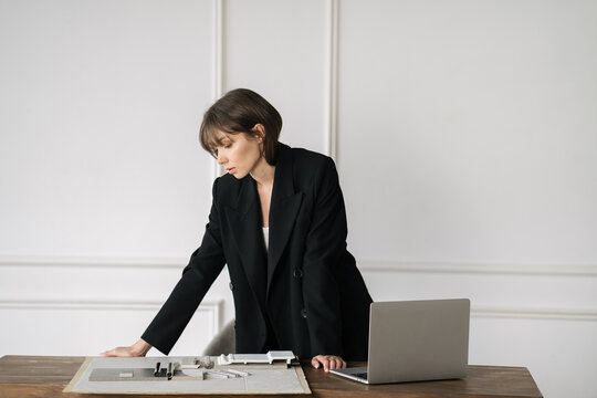 Woman in bright room with laptop and tile examples on a desk