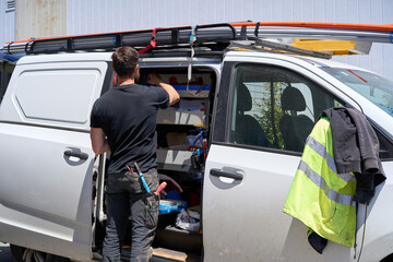 Electrician taking electrical fittings from his van