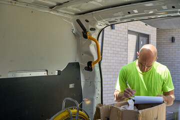 Electrician completing paperwork at job site