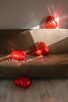 Lots of heart shaped balls glisten on the sofa in the sunlight