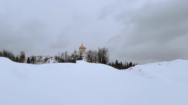 Belogorsky St. Nicholas Orthodox Missionary Monastery. Russia, Perm Krai, Belaya Gora. The temple on the hill in winter. Monastery on the background of snow. 4K