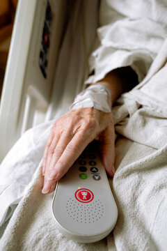 Senior Woman's Hand Holding a Hospital Call Button 