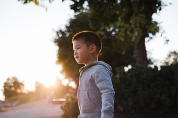 Cute toddler boy exploring the world outdoors at sunset.