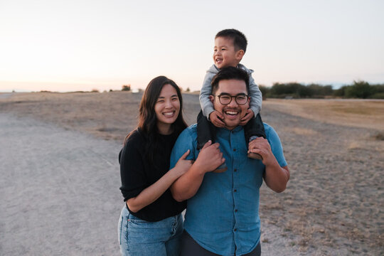 Family of three enjoying time together outside on walking path.