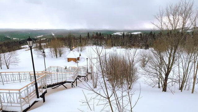 View of the chapel near the Belogorsky St. Nicholas Orthodox Missionary Monastery. Winter forest. The temple on the hill in winter. Russia, Perm Krai, Belaya Gora. 4K