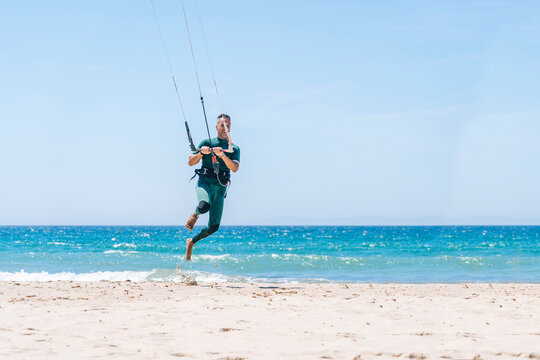 Man trying kitesurfing on sandy beach