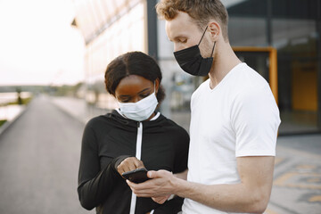 African-american woman and caucasian man looking at the phone while training