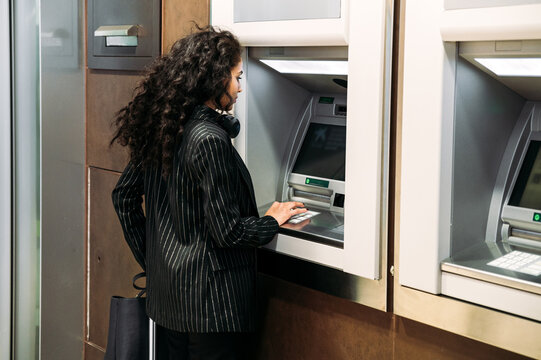 Young woman using ATM machine