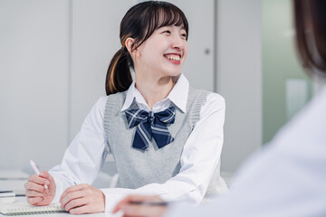 教室で休み時間に話す女子高生