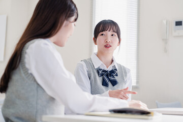 教室で休み時間に話す女子高生