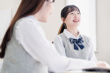 教室で休み時間に話す女子高生