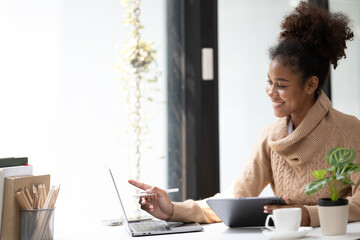 American African Woman working in the office with computer phone and Tablet.