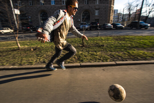 Joyful Guy Runs Down On Street With Soccer Ball