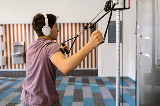 Teenager Boy muscle-building At Fit Gym