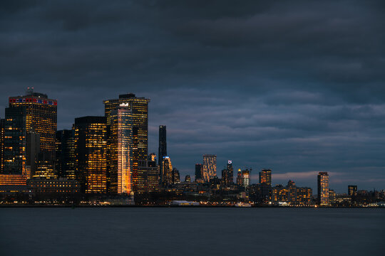 Fototapeta Manhattan and financial district at night, city lights and clouds