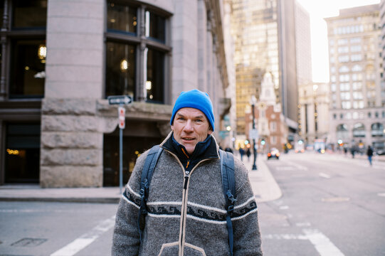 Middle aged man wearing coat and blue hat in Boston 