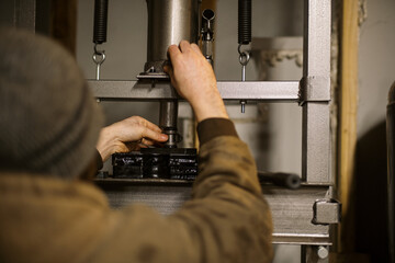 Mechanic worker installing bearings with a hydraulic press 