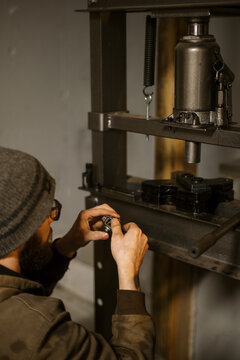 Mechanic worker installing bearings with a hydraulic press 