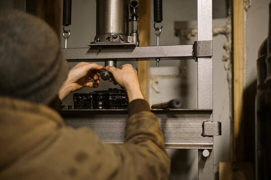 Mechanic worker installing bearings with a hydraulic press 