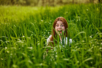 funny woman hiding in tall green grass