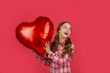 glad teen girl hold love heart balloon on red background