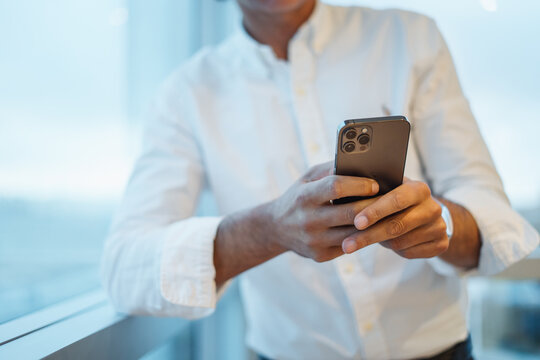 Crop businessman checking messages on smartphone