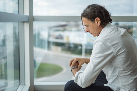 Mature businessman checking time in hotel room