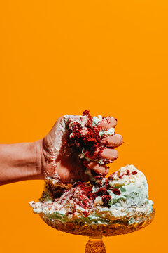 a man squeezes a cake with his hand