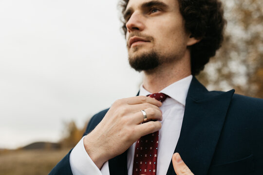 Close-up photo of a man in suite making a tie