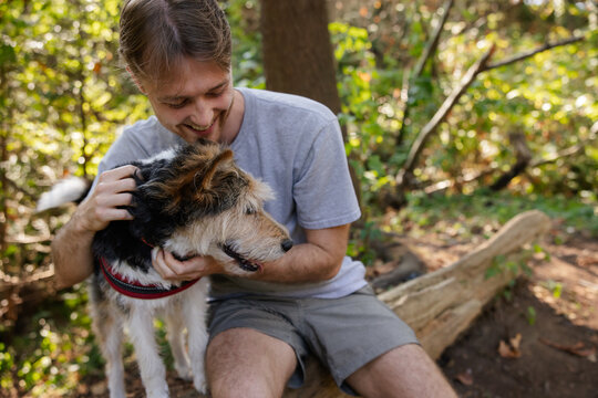 Man showing love to dog outside in nature.