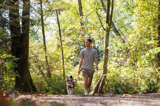 Man enjoying dog walk with wiry pup.