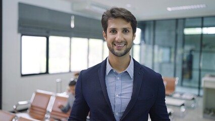 Obraz premium Smiling face of handsome businessman wearing suit standing in airport terminal looking at camera