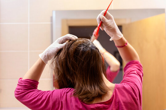 Woman applying hair dye to her hair